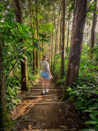 Beautiful Young woman walking up the stairs in the forest, wearing a shirt and shorts. Travel...