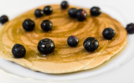 Close up of a tasty american pancake with blueberries and maple syrupの写真素材