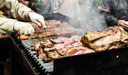 Argentina barbecue asado chorizo sausages and meat cooking on parilla grillの写真素材