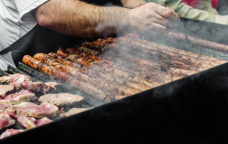 Argentina barbecue asado chorizo sausages and meat cooking on parilla grillの写真素材