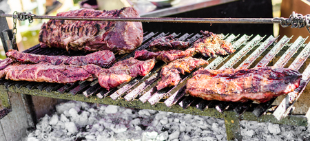 Argentina barbecue asado chorizo sausages and meat cooking on parilla grillの写真素材