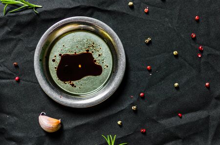 Plate with olive oil and balsamic vinegar against black backgroundの写真素材