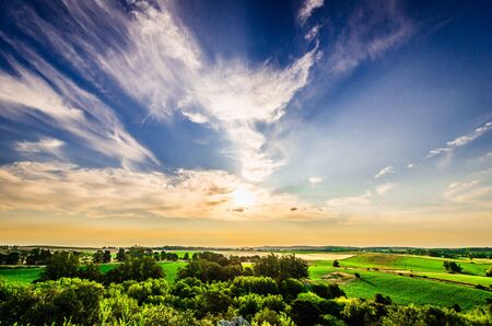 Colorful and bright landscape of valley with green trees and grass and blue skyの写真素材