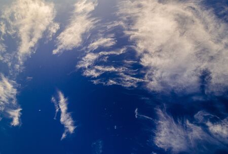 Altocumulus and cirrocumulus white clouds against blue evening skyの写真素材