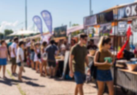 People at a street food market festival on a sunny day. Blurred on purpose.の写真素材
