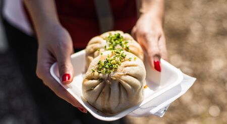 Asian steamed baozi buns with pork and spring onion at a street food marketの写真素材