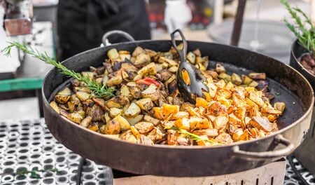 Roasted potatoes with rosemary cooking at a street food marketの写真素材