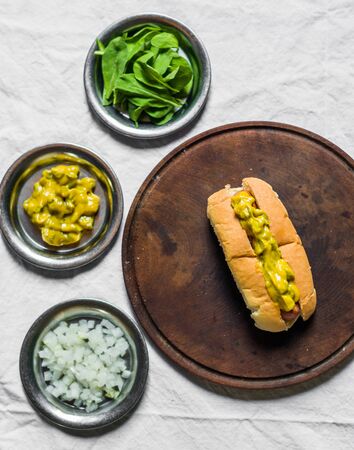 Traditional hot dog with gherkin and mustard relish against white backgroundの写真素材