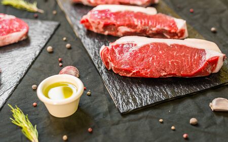 New york strip porterhouse steak beef meat against black backgroundの写真素材