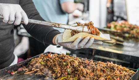 Chef at a street food market preparing a tacoの写真素材
