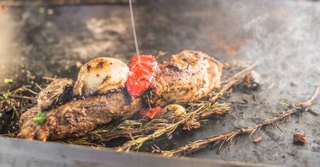 Meat with vegetables frying and smoking at a street food marketの写真素材