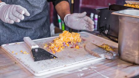 Chef at a street market preparing sandwich with grilled melted cheese and baconの写真素材