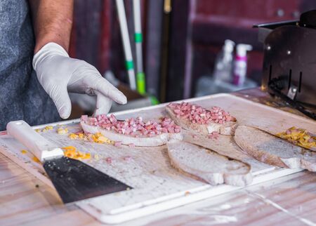 Chef at a street market preparing sandwich with grilled melted cheese and baconの写真素材