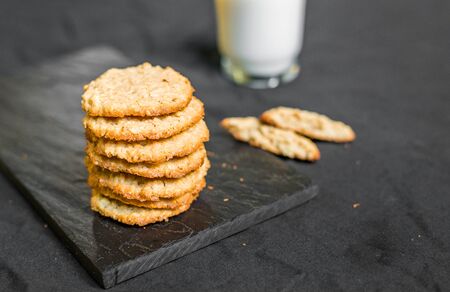 Peanut butter oatmeal cookies with milk against black backgroundの写真素材