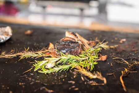 Charred barbecued vegetables frying and smoking at a street food market