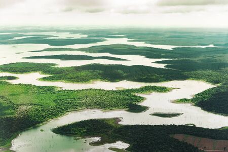 Landscape aerial view of colorful Amazon rivers, forest, jungle, and fieldsの写真素材