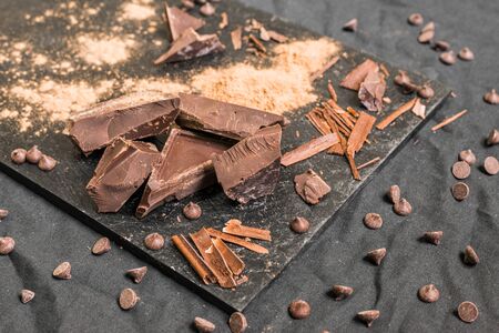 Chocolate with chocolate chips against black background.の写真素材