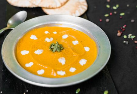 Colorful cream soup with pumpkin and carrot. Healthy food and eating concept.の写真素材