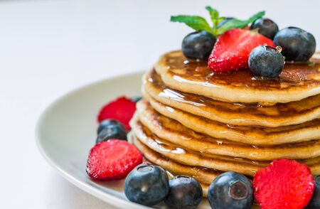 American pancakes with honey against white background.の写真素材