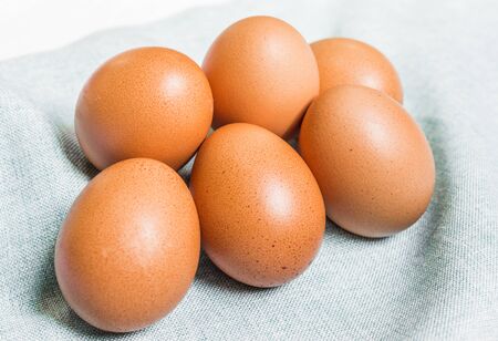 Fresh chicken eggs against white and blue background.の写真素材