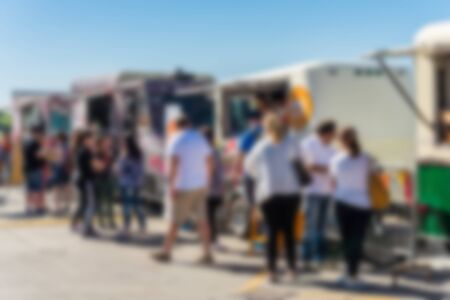 People at a street food market festival on a sunny day. Blurred on purpose.の写真素材