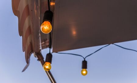 Vintage antique hanging light bulbs at a street food market.の写真素材