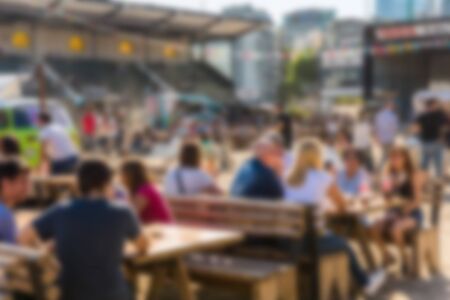People at a street food market festival on a sunny day. Blurred on purpose.の写真素材