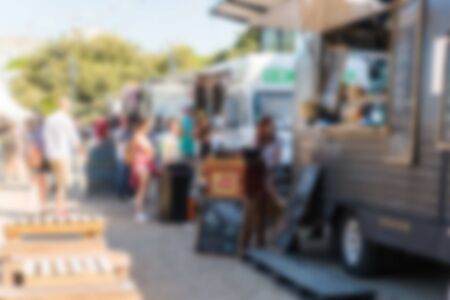 People at a street food market festival on a sunny day. Blurred on purpose.の写真素材
