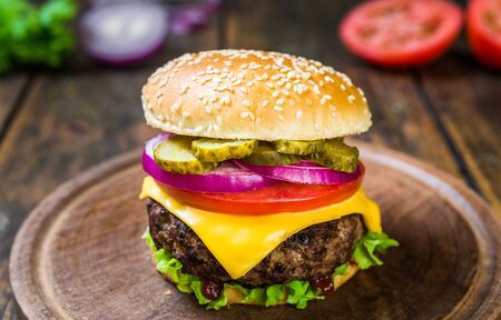 Cheese burger with cheese against wooden background. Tasty fast foodの写真素材