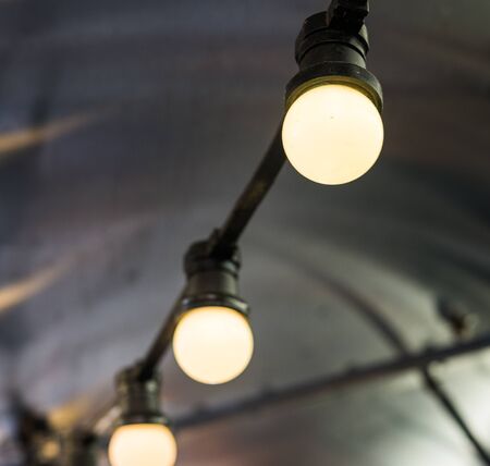 Vintage antique hanging light bulbs at a street food market.の写真素材