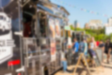 People at a street food market festival on a sunny day. Blurred on purpose.の写真素材