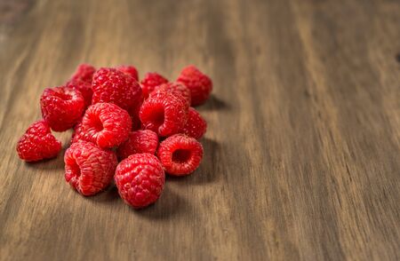 Fresh colorful organic raspberry fruit against wooden background.の写真素材