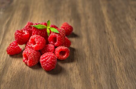 Fresh colorful organic raspberry fruit against wooden backgroundの写真素材