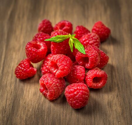 Fresh colorful organic raspberry fruit against wooden background.の写真素材