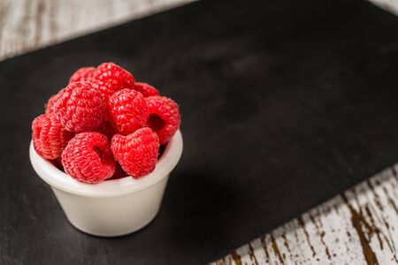 Fresh colorful organic raspberry fruit against slate backgroundの写真素材