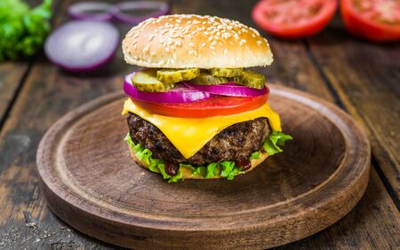 Cheese burger with cheese against wooden background. Tasty fast foodの写真素材