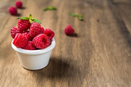 Fresh colorful organic raspberry fruit against wooden backgroundの写真素材
