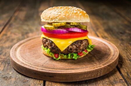 Cheese burger with cheese against wooden background. Tasty fast foodの写真素材