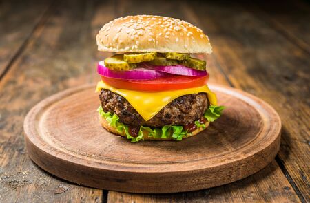 Cheese burger with cheese against wooden background. Tasty fast foodの写真素材