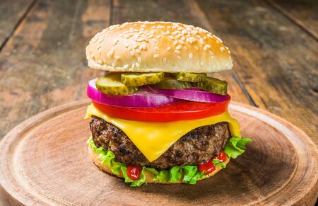 Cheese burger with cheese against wooden background. Tasty fast foodの写真素材