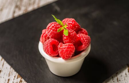 Fresh colorful organic raspberry fruit against slate backgroundの写真素材