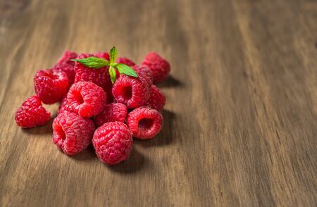 Fresh colorful organic raspberry fruit against wooden backgroundの写真素材