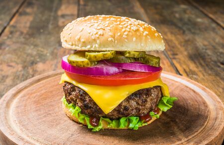 Cheese burger with cheese against wooden background. Tasty fast foodの写真素材
