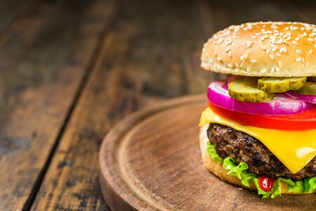 Cheese burger with cheese against wooden background. Tasty fast food.の写真素材