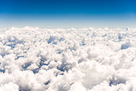 Abstract skyscape background with white cumulus clouds against blue skyの写真素材