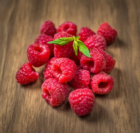 Fresh colorful organic raspberry fruit against wooden background.の写真素材