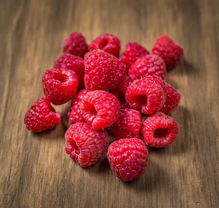Fresh colorful organic raspberry fruit against wooden background.の写真素材