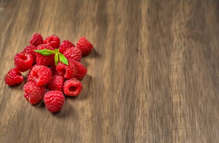 Fresh colorful organic raspberry fruit against wooden background.の写真素材