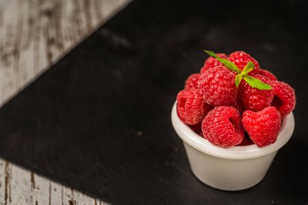Fresh colorful organic raspberry fruit against slate background.の写真素材