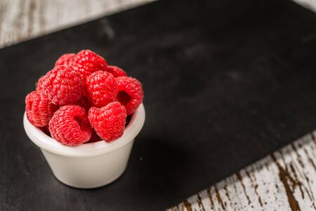 Fresh colorful organic raspberry fruit against slate background.の写真素材